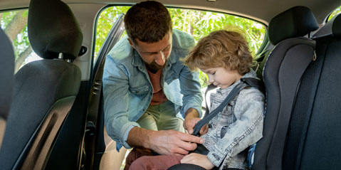CAAS volunteer helping child with seatbelt