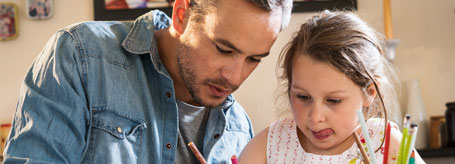 Father and daughter colouring together